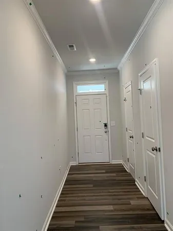 a view of a hallway with wooden floor and closet