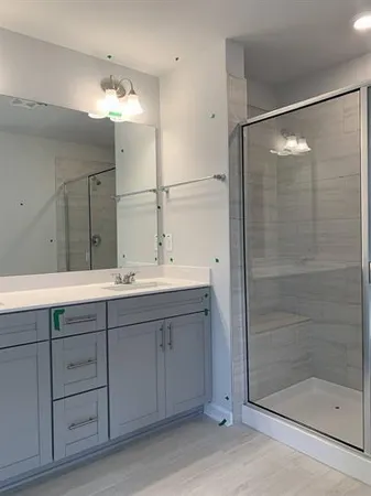 a bathroom with a double vanity sink mirror and shower