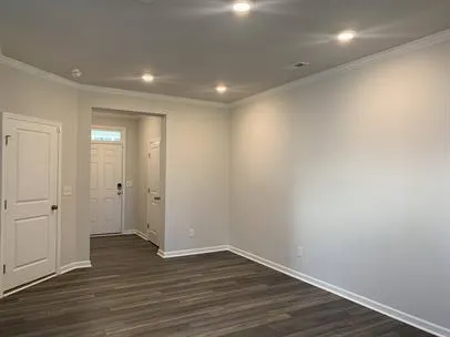 a view of an empty room with wooden floor