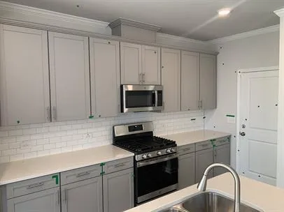 a kitchen with stainless steel appliances granite countertop a stove a sink and a microwave