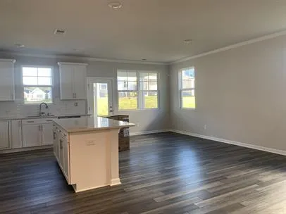 a kitchen with granite countertop a stove top oven sink and cabinets