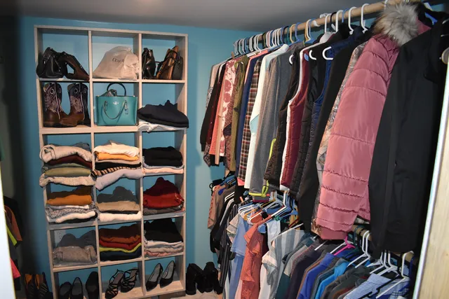 a view of walk in closet with clothes and shoes