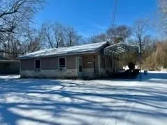 a front view of house with yard and trees in the background