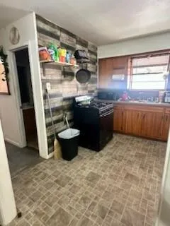 a kitchen with stainless steel appliances granite countertop a sink and a stove