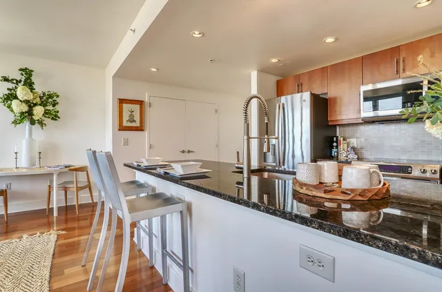 a kitchen with stainless steel appliances granite countertop a refrigerator a stove and a sink