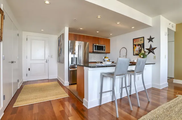 a kitchen with stainless steel appliances granite countertop a refrigerator and a stove top oven