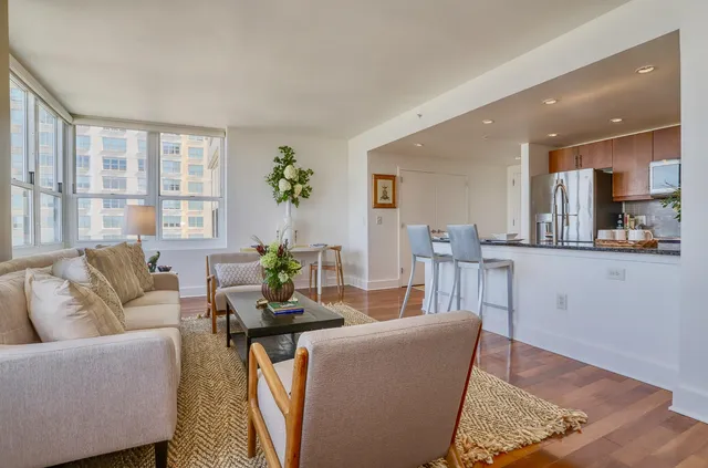 a living room with furniture a wooden floor and a large window