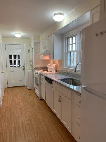 a kitchen with sink cabinets and wooden floor