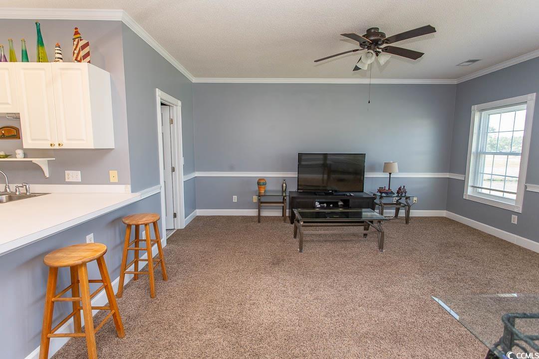 4823 Orchid Way, Unit 2203 Myrtle Beach, SC 29577 - Photo 12 of 36 Living area with ceiling fan, light colored carpet, baseboards, ornamental molding, and visible vents