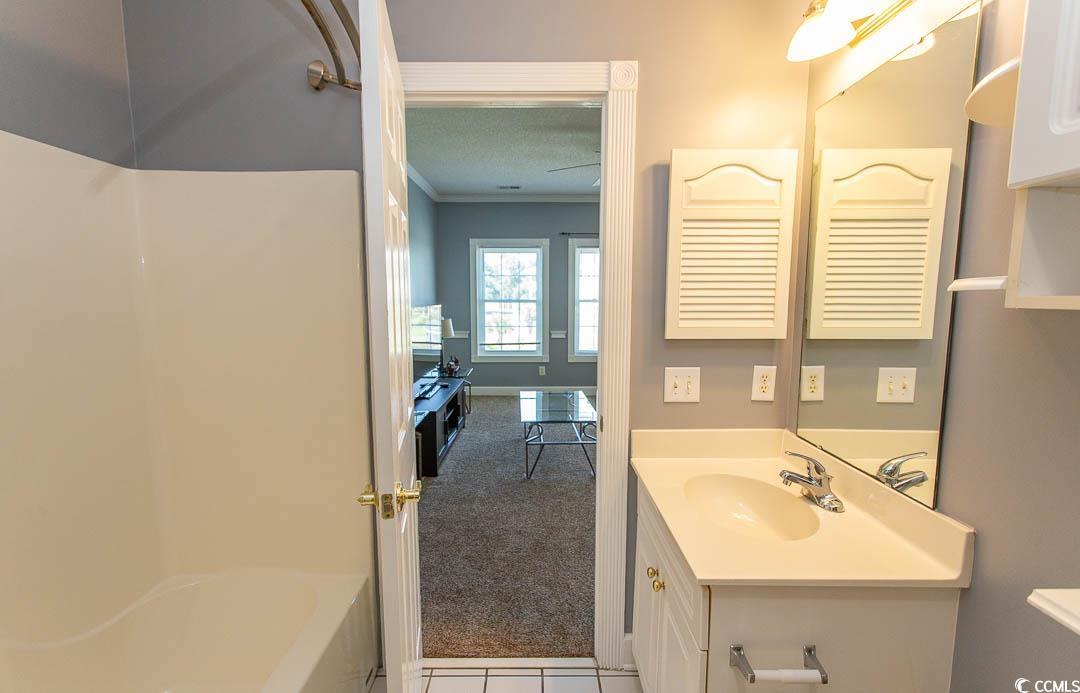4823 Orchid Way, Unit 2203 Myrtle Beach, SC 29577 - Photo 16 of 36 Bathroom with walk in shower, vanity, ornamental molding, and a bathing tub