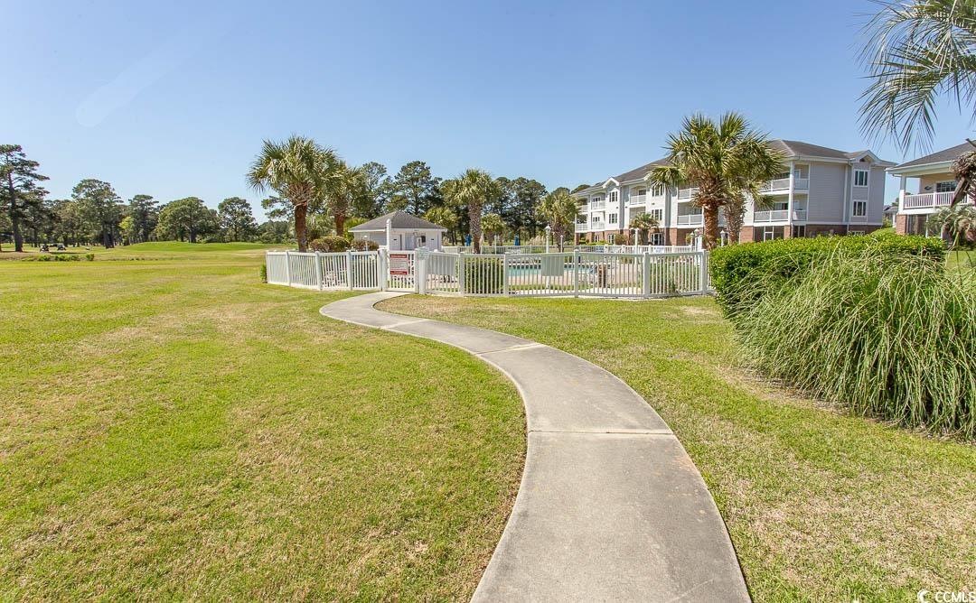 4823 Orchid Way, Unit 2203 Myrtle Beach, SC 29577 - Photo 32 of 36 View of property's community featuring a residential view, a lawn, and fence