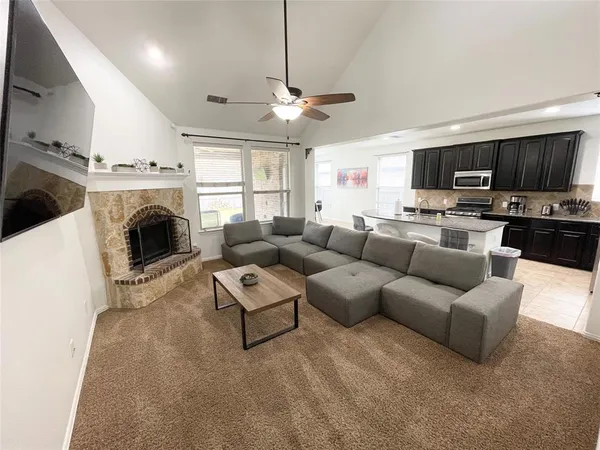 a living room with furniture a flat screen tv and a fireplace