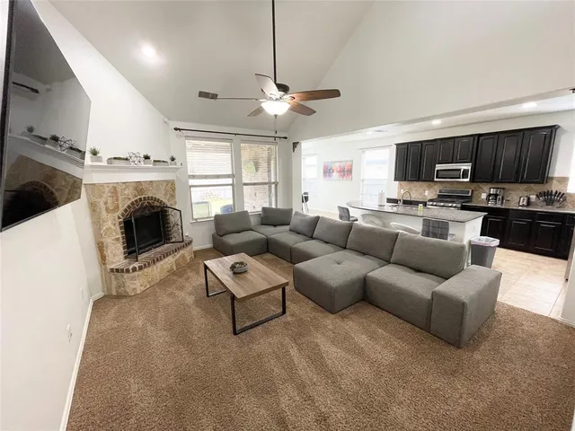 a living room with furniture a flat screen tv and a fireplace