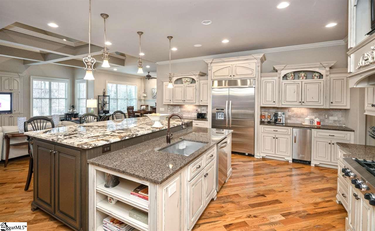 211 New Castle Drive Duncan, SC 29334 - Photo 5 of 36 The Chef will enjoy cooking AND conversing with family/friends sitting at the expansive custom tiered island! Great usable space including farm sink, open and closed shelving and stunning granite (1 pc. no seams) Hardwoods on the DIAGONAL, stunning!