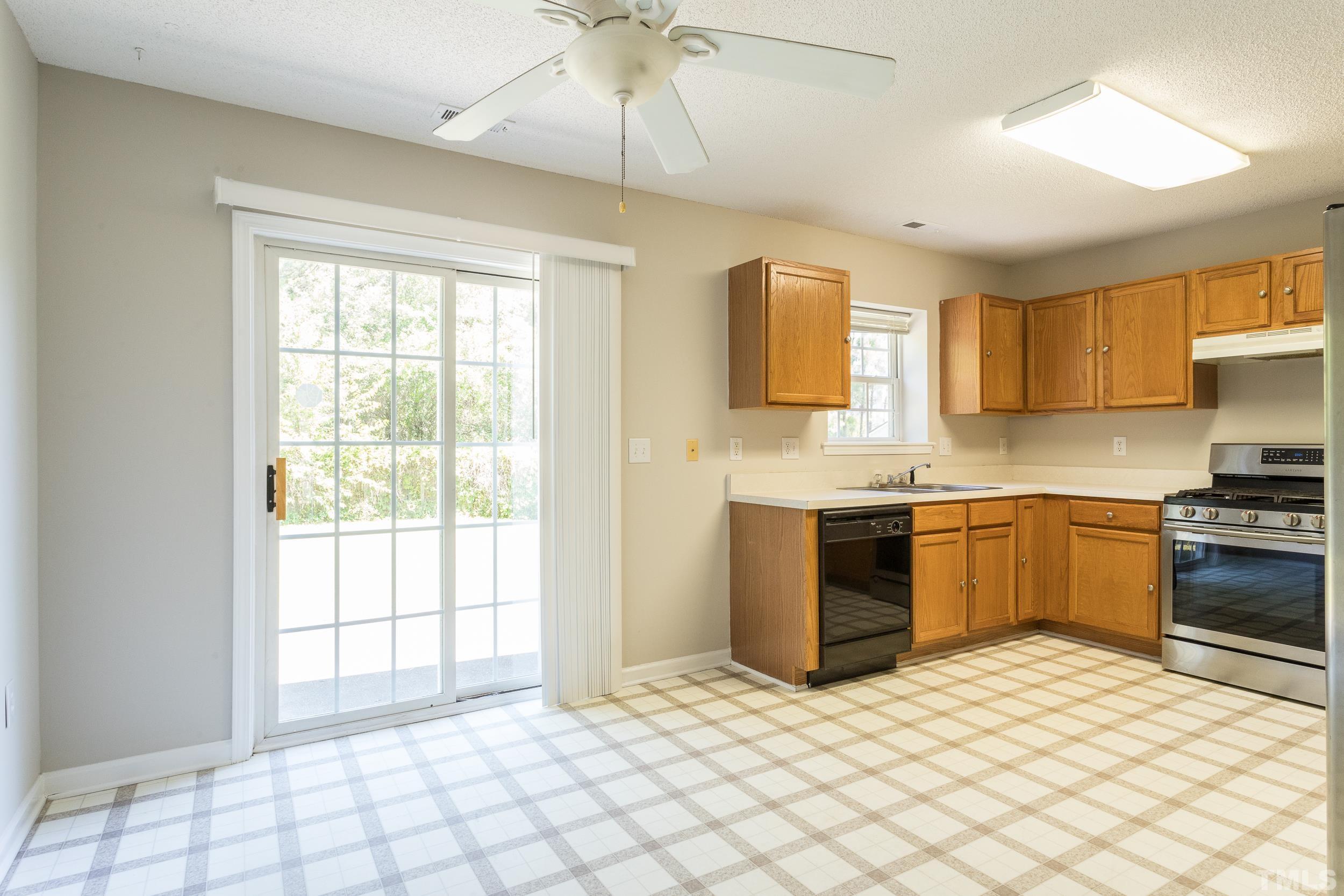 4411 Nightfall Court Durham, NC 27713 - Photo 11 of 28 a kitchen with a stove a sink and a refrigerator
