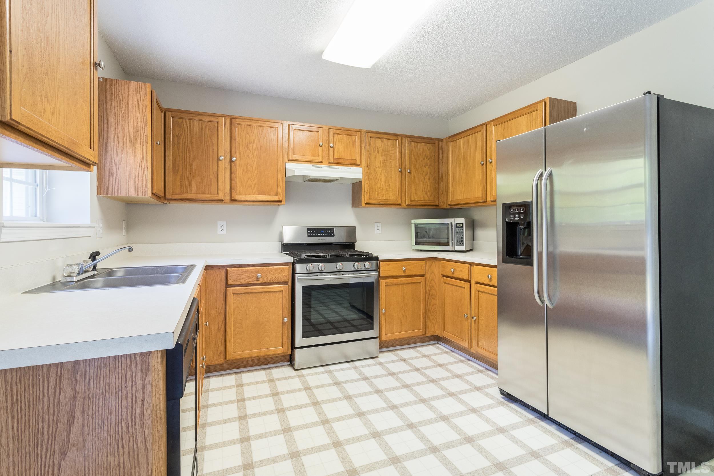4411 Nightfall Court Durham, NC 27713 - Photo 13 of 28 a kitchen with a refrigerator sink and stove