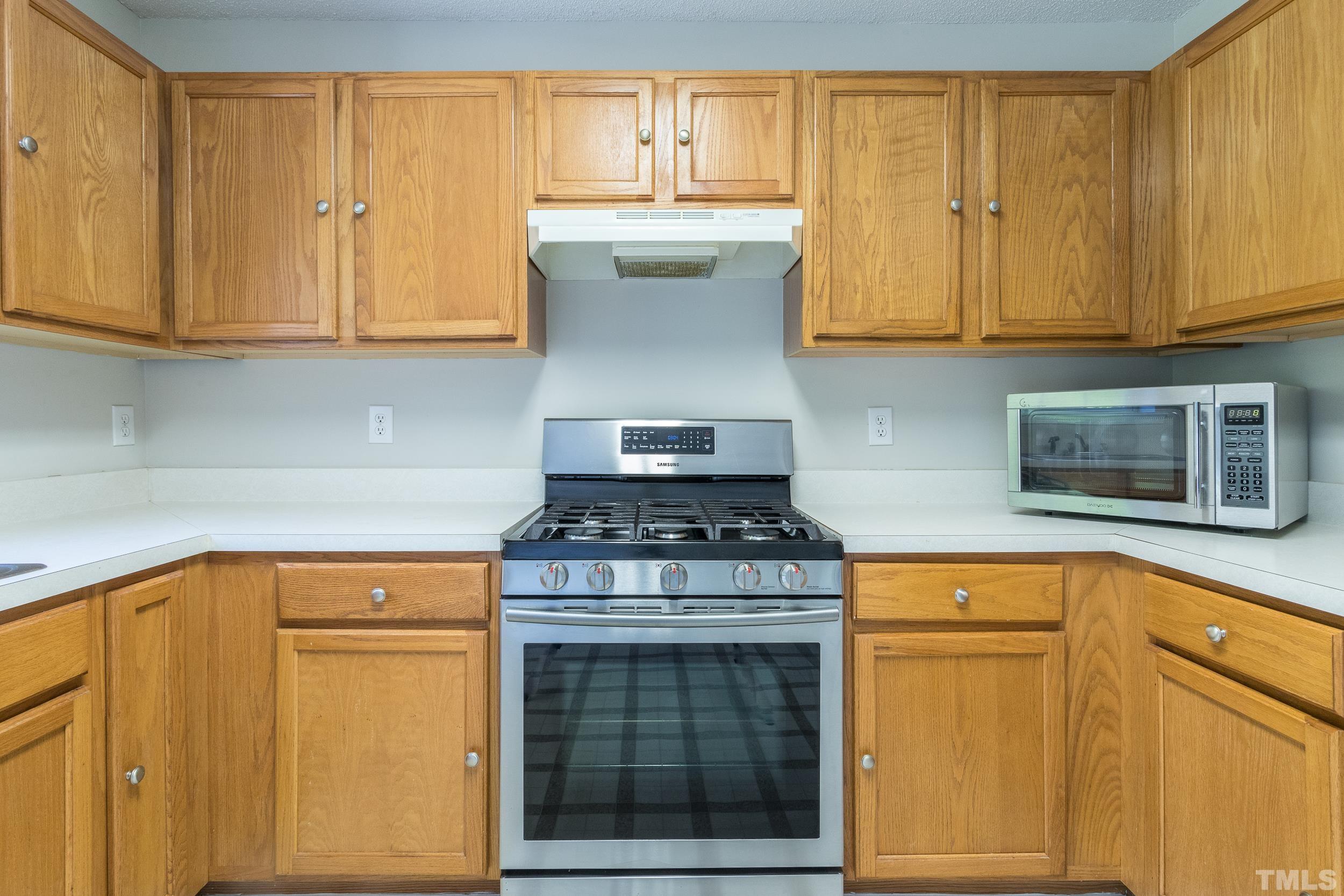 4411 Nightfall Court Durham, NC 27713 - Photo 15 of 28 a kitchen with stainless steel appliances granite countertop cabinets and a stove top oven