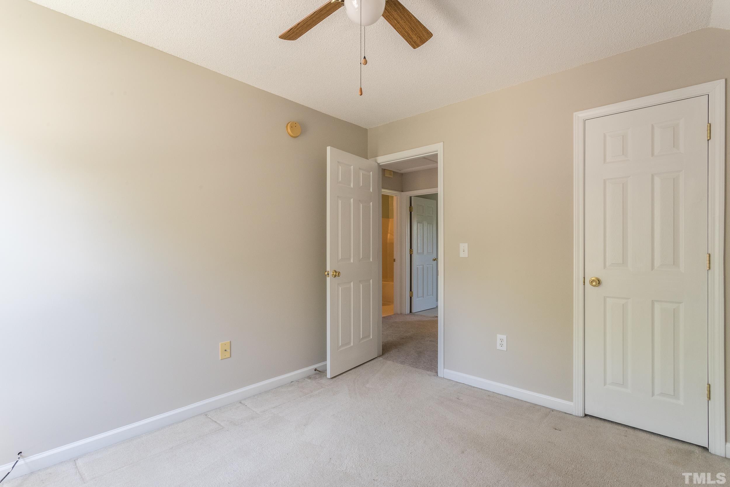 4411 Nightfall Court Durham, NC 27713 - Photo 19 of 28 an empty room with a ceiling fan and carpet