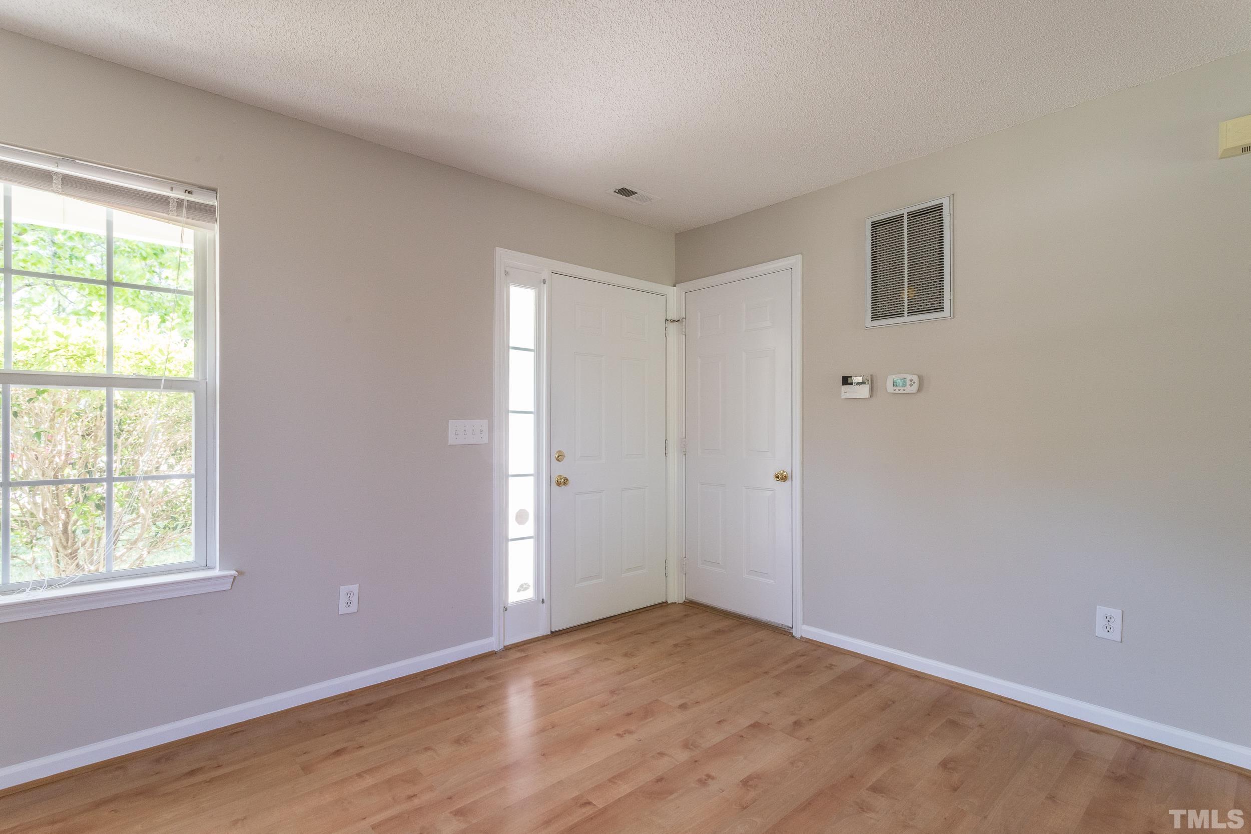 4411 Nightfall Court Durham, NC 27713 - Photo 9 of 28 a view of an empty room with wooden floor and a window