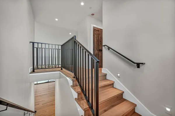 a kitchen with stainless steel appliances granite countertop a refrigerator a sink and wooden floor