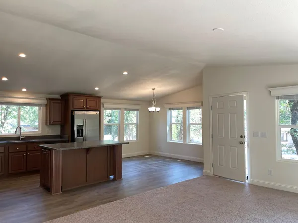 a kitchen with kitchen island granite countertop wooden floors and stainless steel appliances