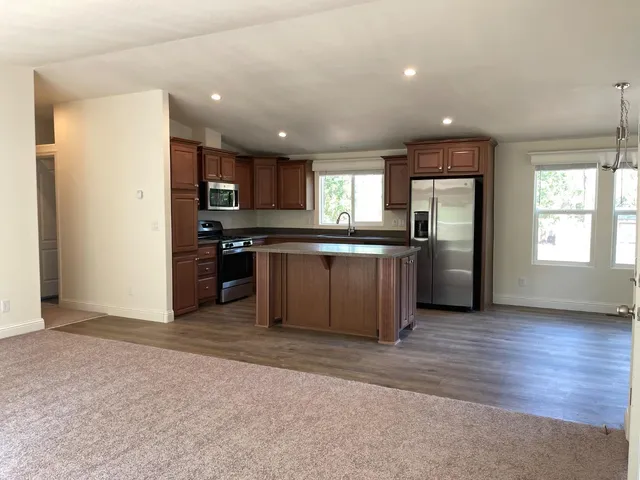 a large kitchen with stainless steel appliances granite countertop a stove and a refrigerator