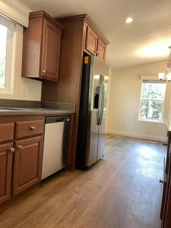 a view of a refrigerator a window and wooden floor