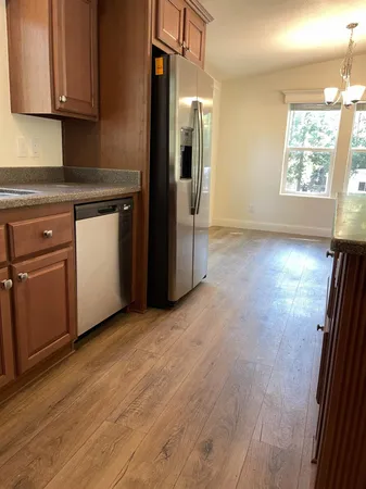 a view of a kitchen with wooden floor and electronic appliances