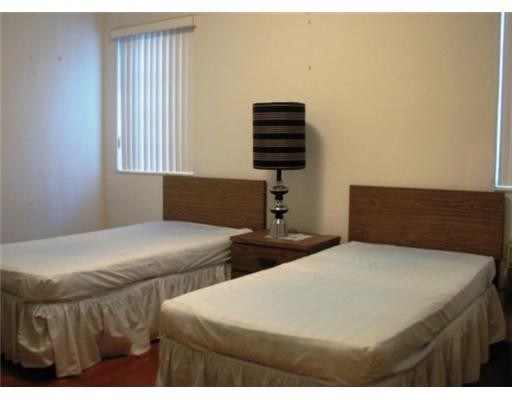 205 Southwest 21st Road Miami, FL 33129 - Photo 8 of 12 a bedroom with two beds and a chandelier