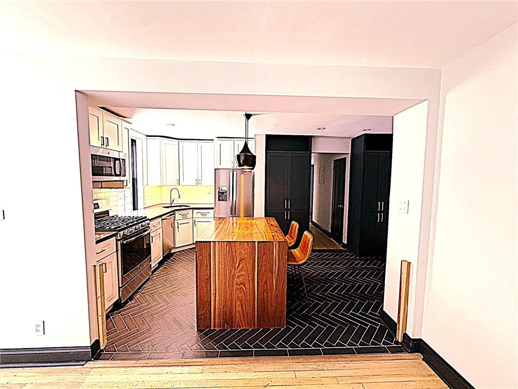 302 96th Street, Unit 1P Brooklyn, NY 11209 - Photo 3 of 11 a kitchen with stainless steel appliances granite countertop a refrigerator and a stove