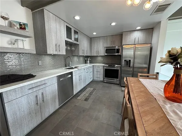 a large kitchen with stainless steel appliances kitchen island granite countertop a sink and cabinets