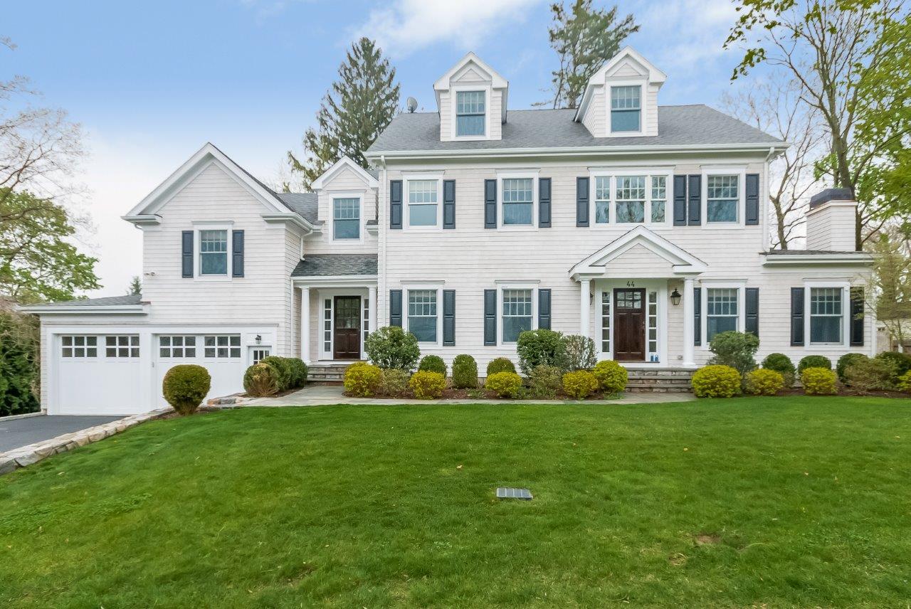 a front view of a house with a yard and trees