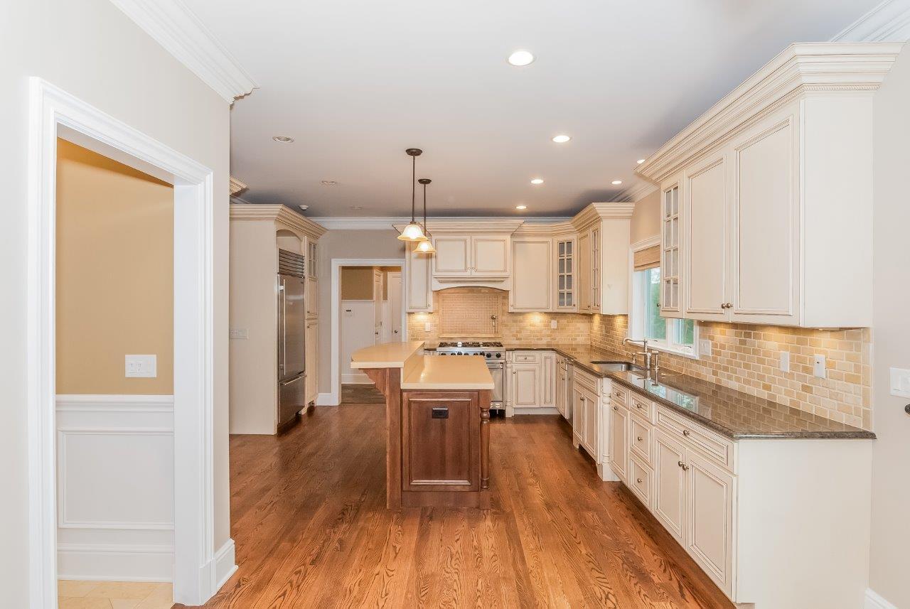 44 Gower Road New Canaan, CT 06840 - Photo 18 of 53 a large kitchen with a center island wooden floor stainless steel appliances and windows