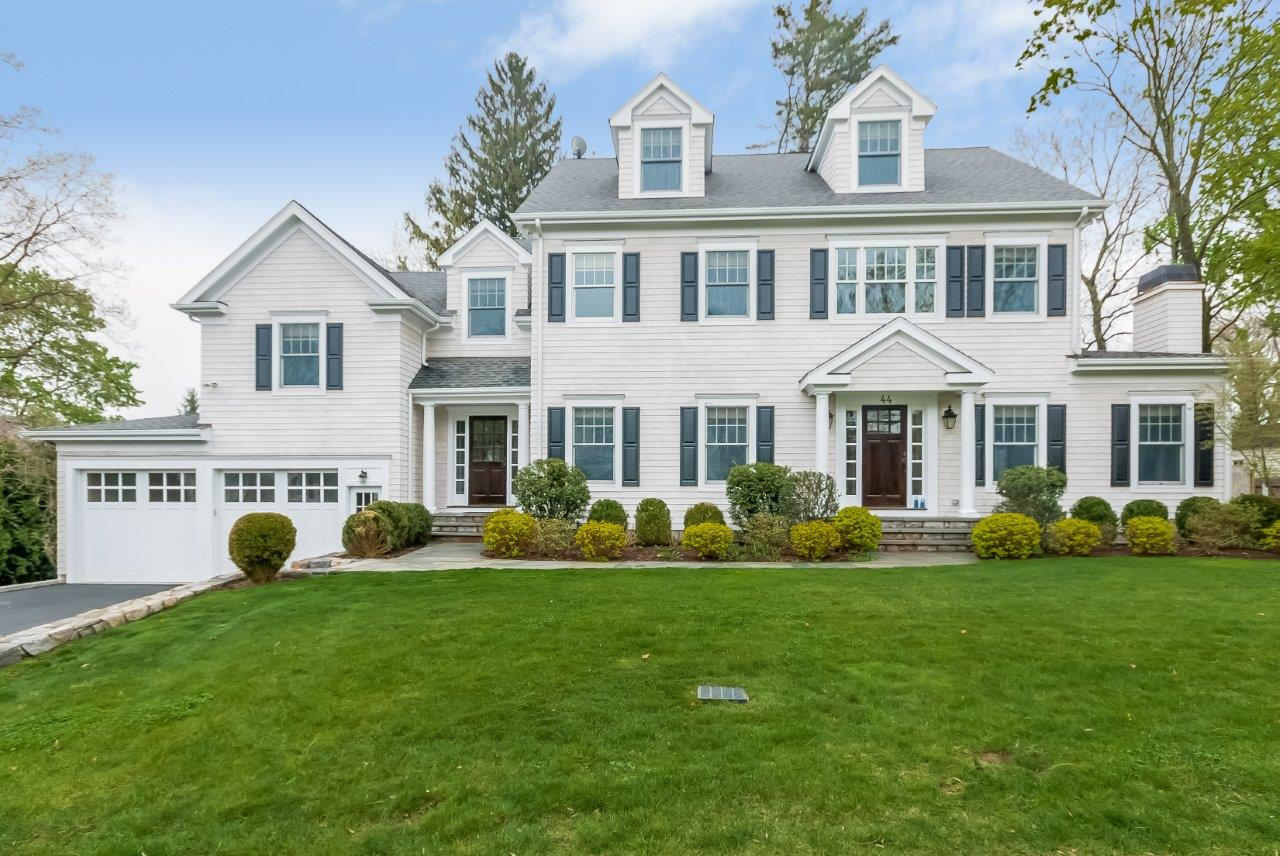 44 Gower Road New Canaan, CT 06840 - Photo 2 of 53 a front view of a house with a yard and trees