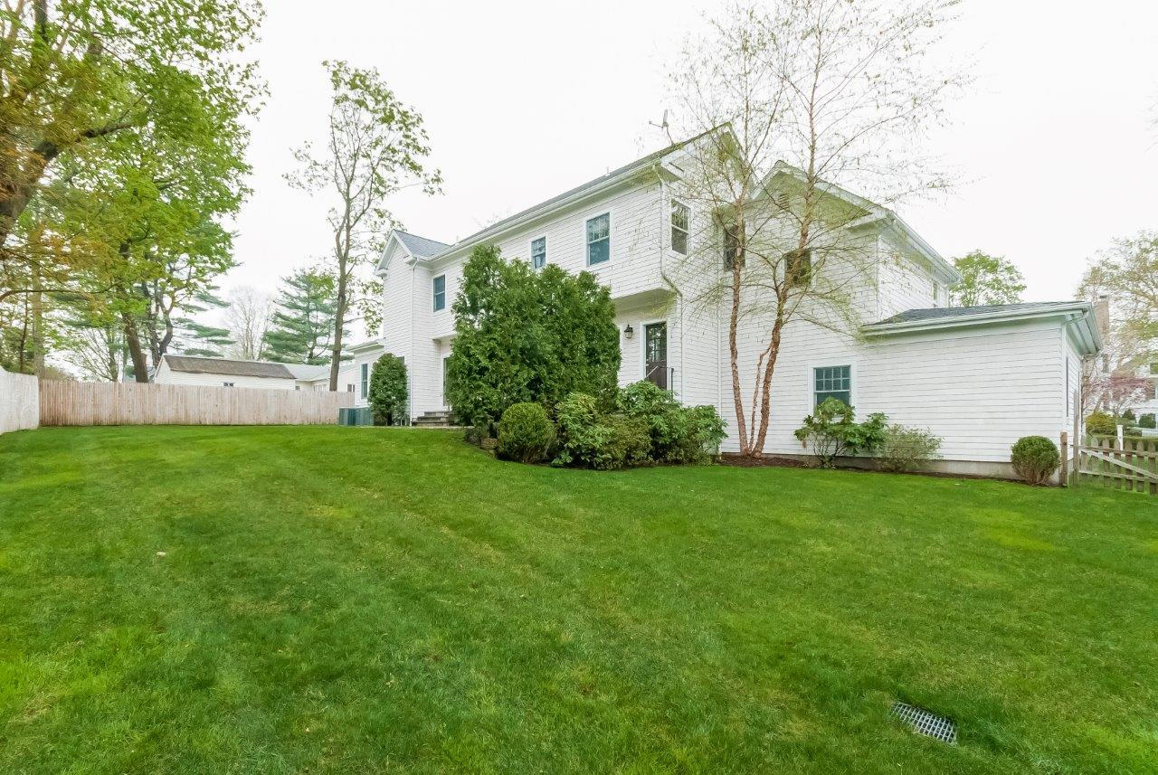 44 Gower Road New Canaan, CT 06840 - Photo 8 of 53 a view of a white house next to a yard with big trees