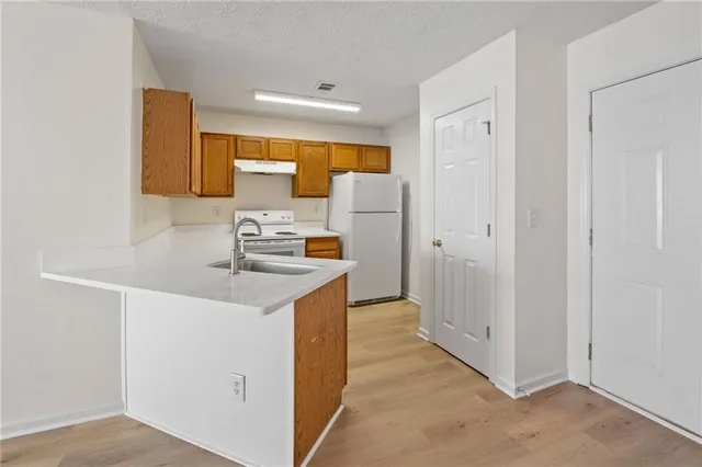 a kitchen with a sink a refrigerator and a cabinets