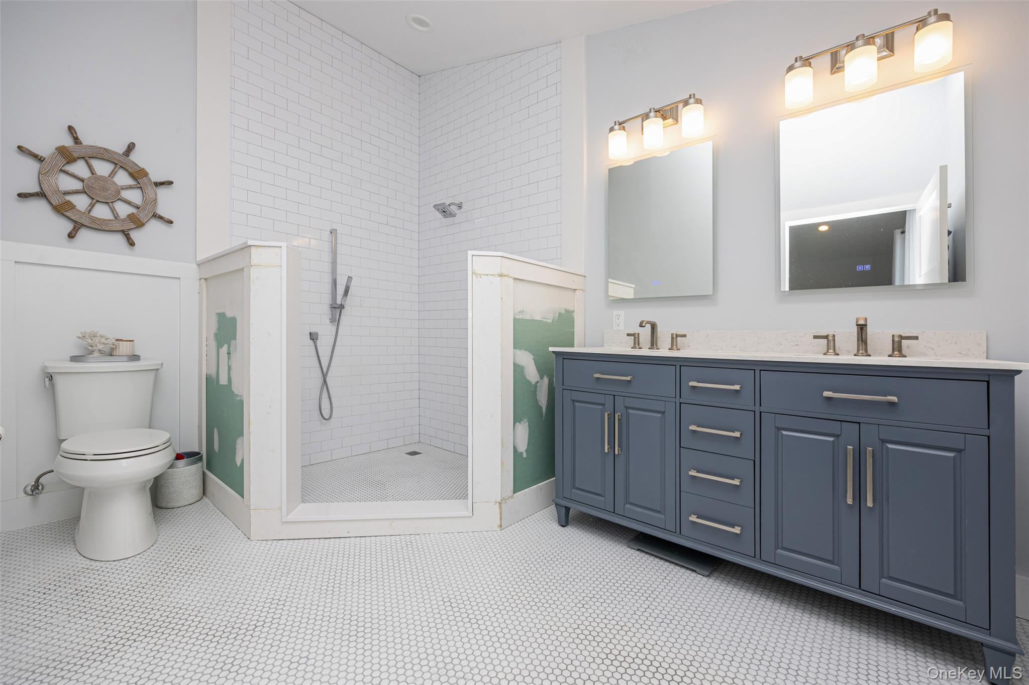390 East Shore Road Lindenhurst, NY 11757 - Photo 11 of 27 a bathroom with a toilet a double vanity sink and mirror