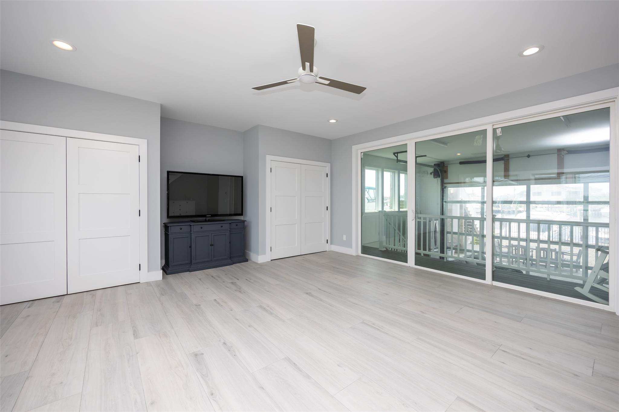 390 East Shore Road Lindenhurst, NY 11757 - Photo 15 of 27 Unfurnished living room with a ceiling fan, light wood-style floors, and recessed lighting