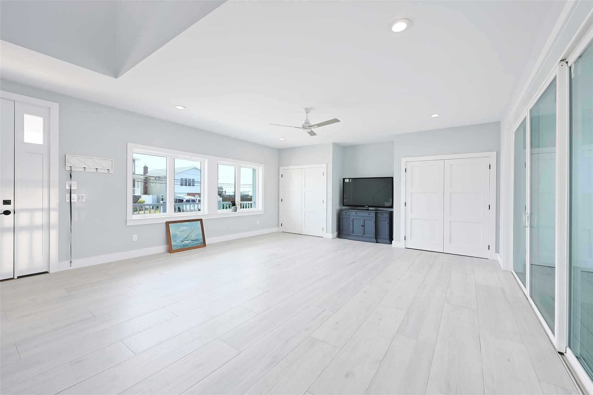 390 East Shore Road Lindenhurst, NY 11757 - Photo 17 of 27 Unfurnished living room featuring ceiling fan, recessed lighting, and light wood-style flooring