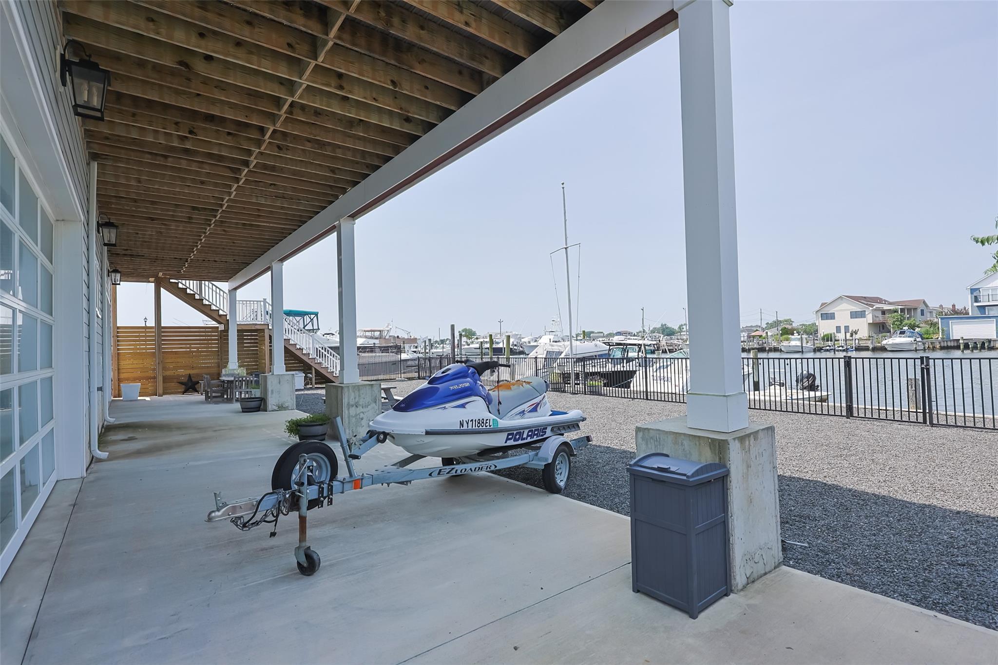 390 East Shore Road Lindenhurst, NY 11757 - Photo 20 of 27 View of patio featuring stairs, a water view, a dock, and boat lift