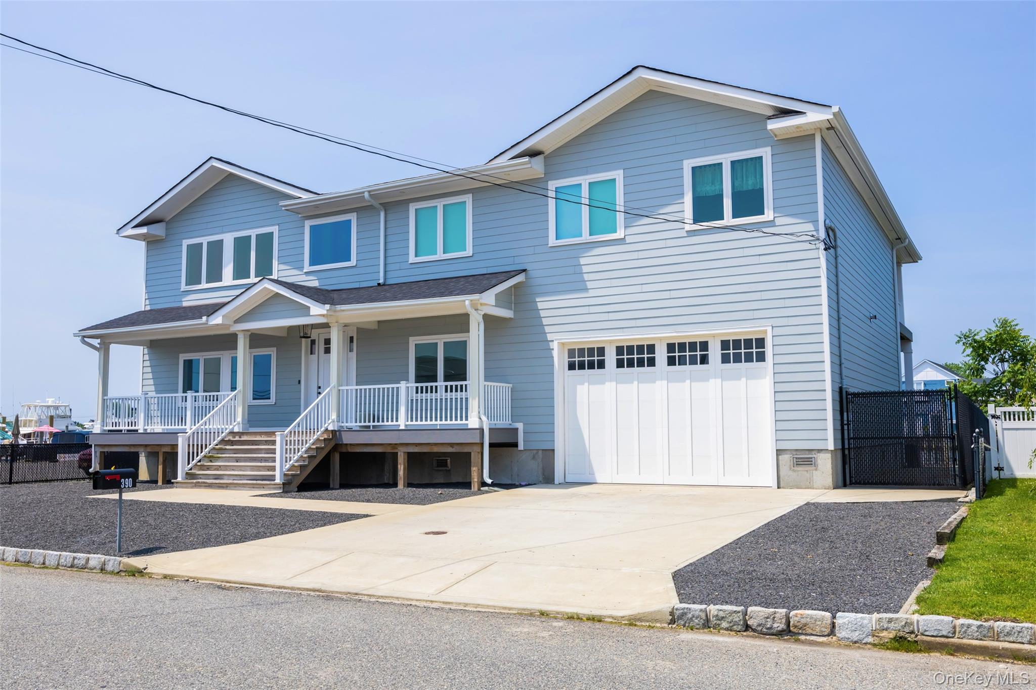 390 East Shore Road Lindenhurst, NY 11757 - Photo 21 of 27 a front view of a house with a yard and garage