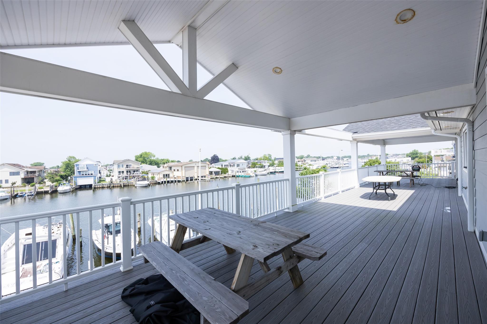390 East Shore Road Lindenhurst, NY 11757 - Photo 25 of 27 Wooden terrace featuring outdoor dining space, a water view, and a residential view