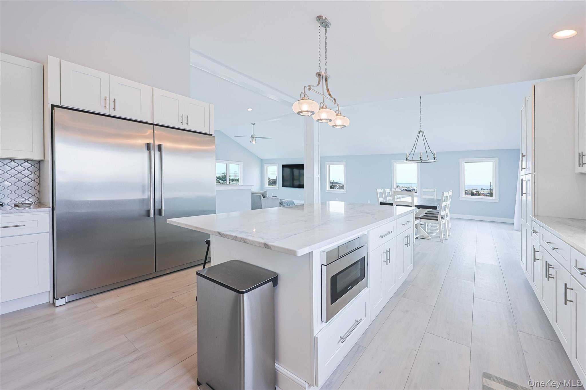 390 East Shore Road Lindenhurst, NY 11757 - Photo 7 of 27 a large kitchen with kitchen island a stove a sink a refrigerator and a chandelier