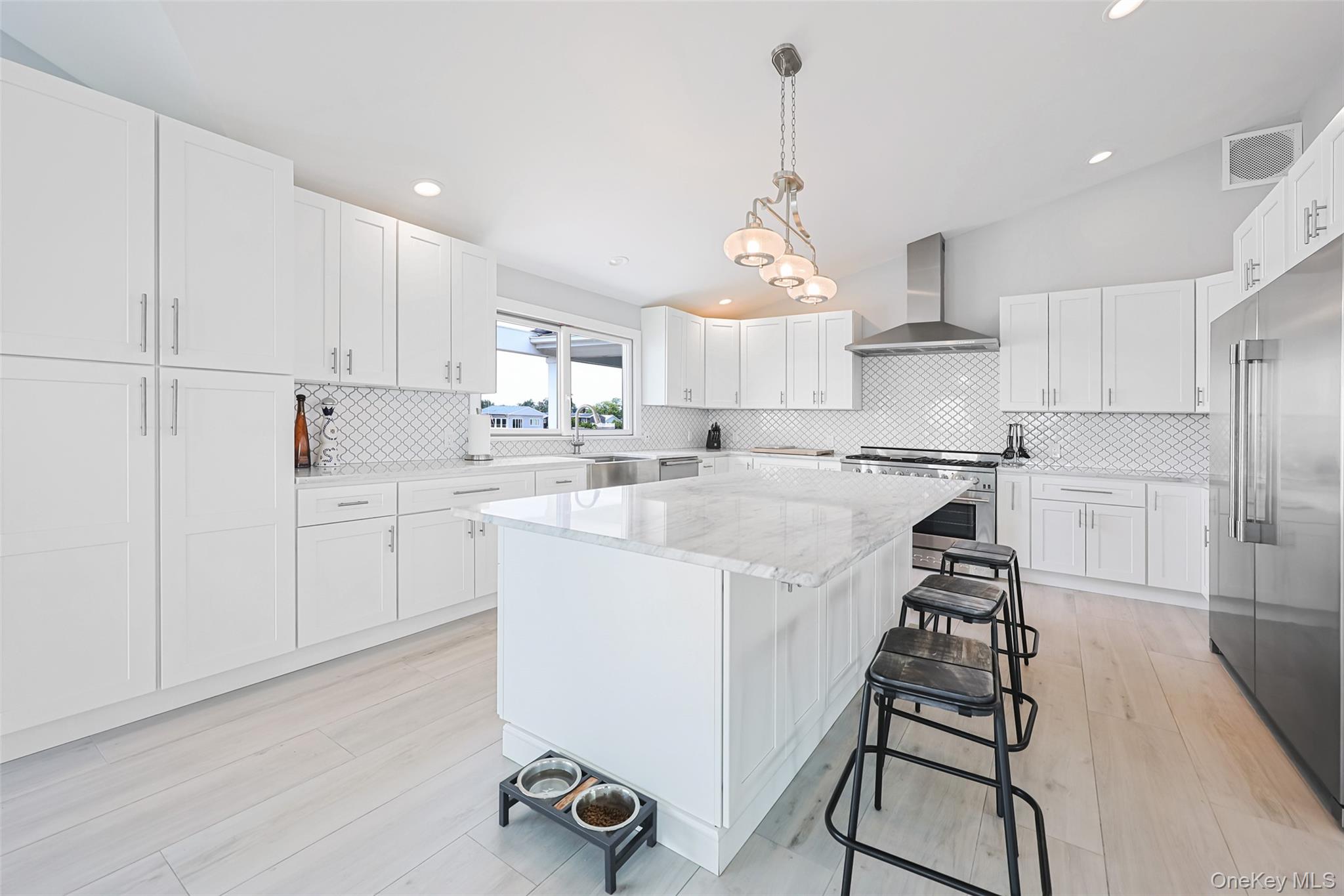 390 East Shore Road Lindenhurst, NY 11757 - Photo 9 of 27 a kitchen with kitchen island a stove a sink and a refrigerator