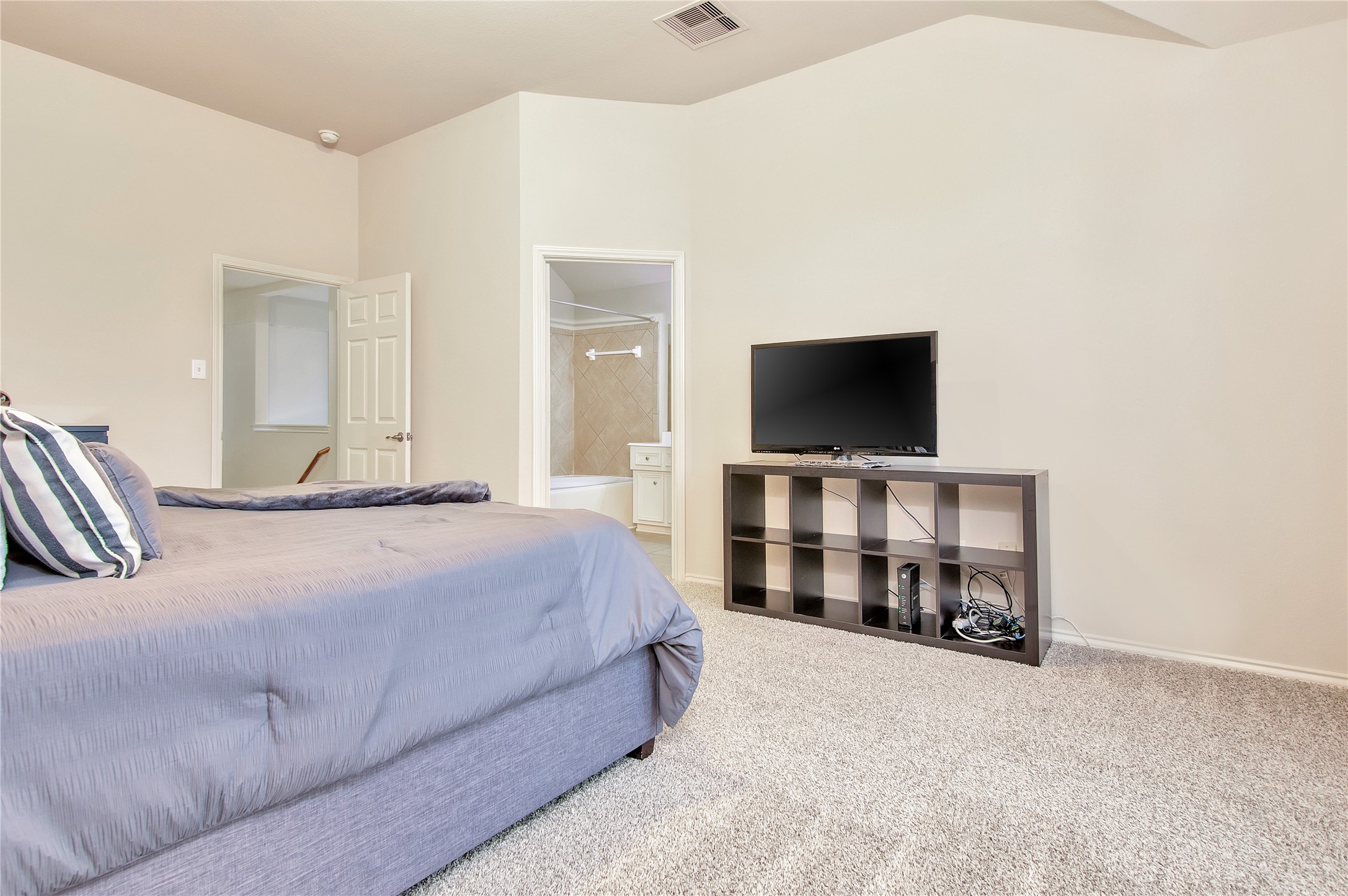 16518 Strathmore Manor Lane Houston, TX 77090 - Photo 14 of 25 a bedroom with a bed and a flat screen tv