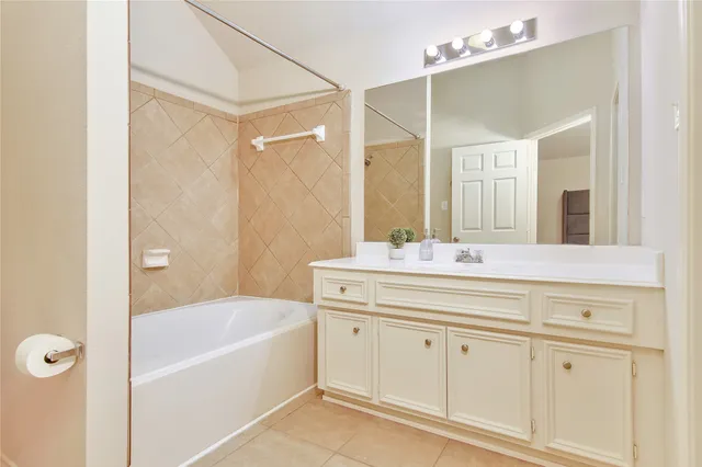 a bathroom with a tub a sink and mirror