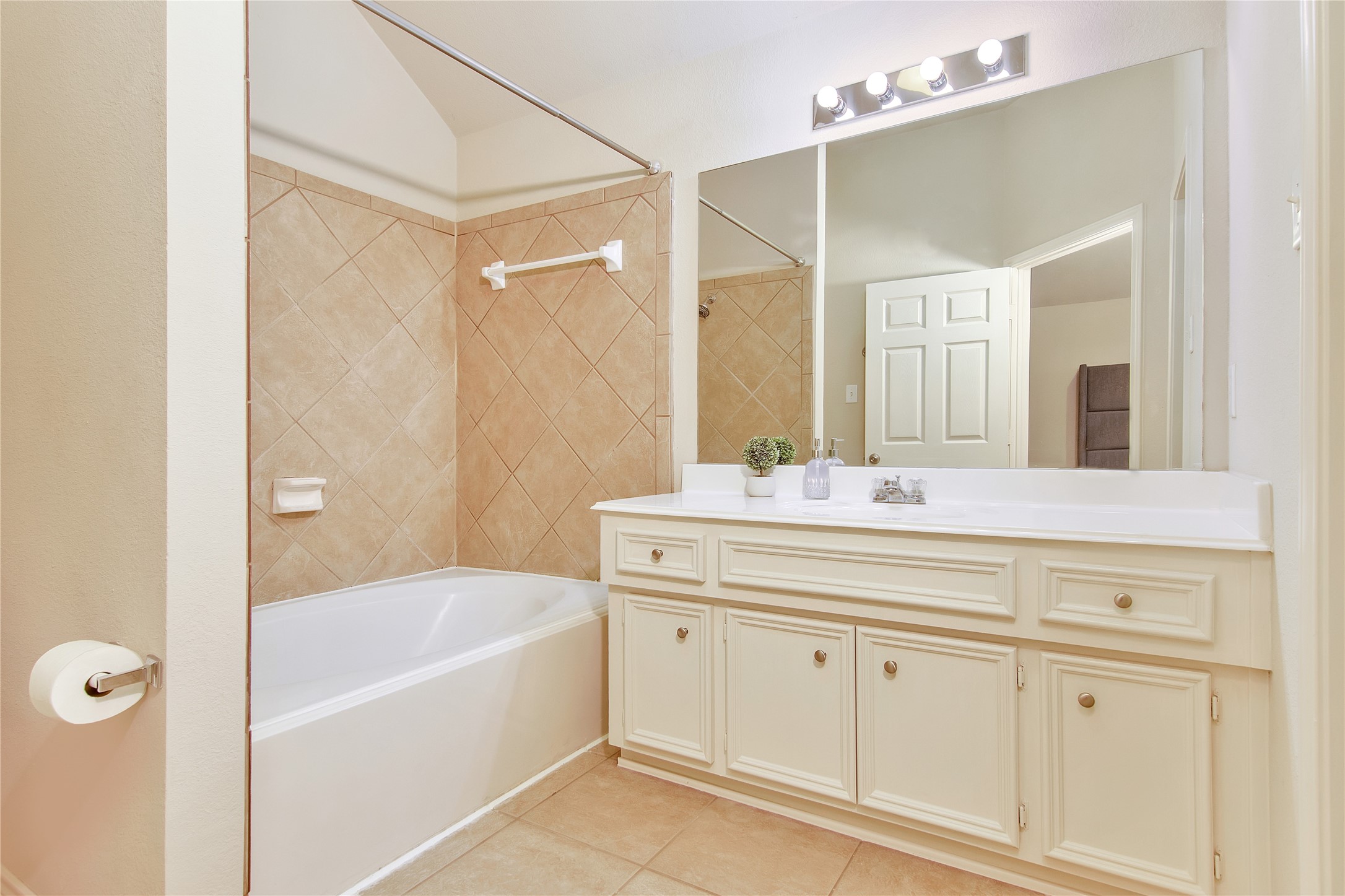 16518 Strathmore Manor Lane Houston, TX 77090 - Photo 16 of 25 a bathroom with a tub a sink and mirror
