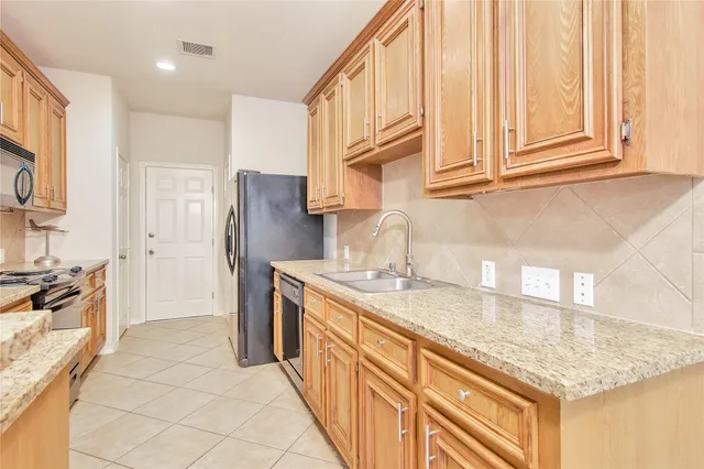 a kitchen with stainless steel appliances granite countertop a sink stove and refrigerator
