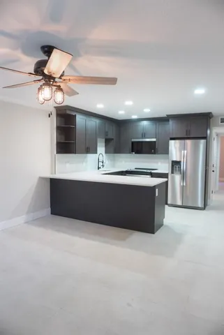 a kitchen with stainless steel appliances a sink a refrigerator and a stove