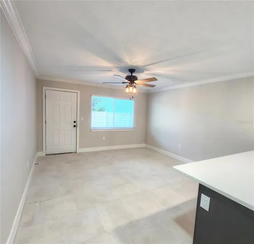 an empty room with a ceiling fan and a window
